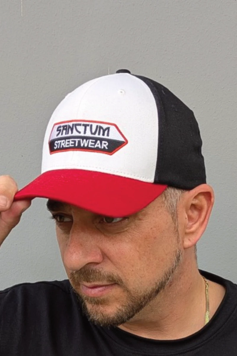 Das moderne Flexfit Cap im dreifarbigen Style zeichnet sich mit vorgebogenem Visor und integriertem Gummiband für den richtigen Halt am Kopf aus.  Die Farben schwarz, weiß und rot sind passend zum eingestickten Sanctum Streetwear Logo und verleihen dem Cap dadurch die besondere Optik.
