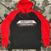 Schwarzer Hoodie mit roten Ärmeln und roter Kapuze. Sanctum Streetwear Logo auf der Brust